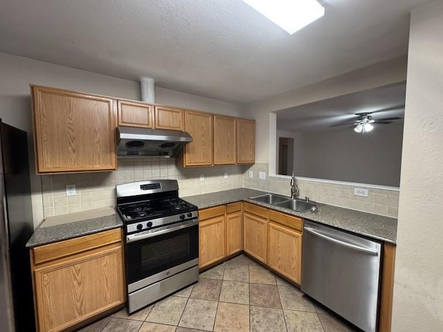 kitchen with sink, ceiling fan, appliances with stainless steel finishes, tasteful backsplash, and light tile patterned flooring