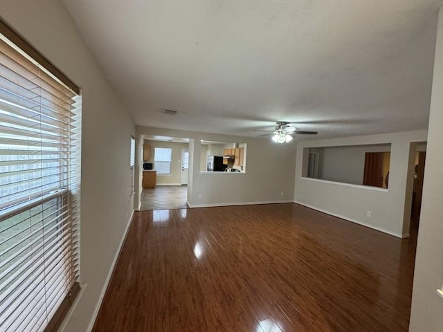 unfurnished living room featuring ceiling fan and dark hardwood / wood-style flooring