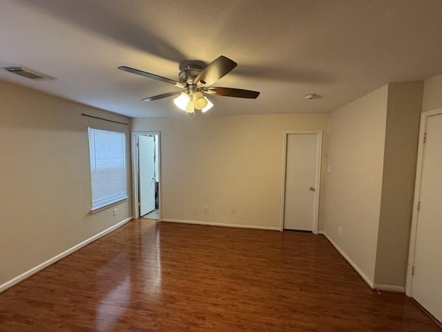 spare room with dark hardwood / wood-style floors and ceiling fan