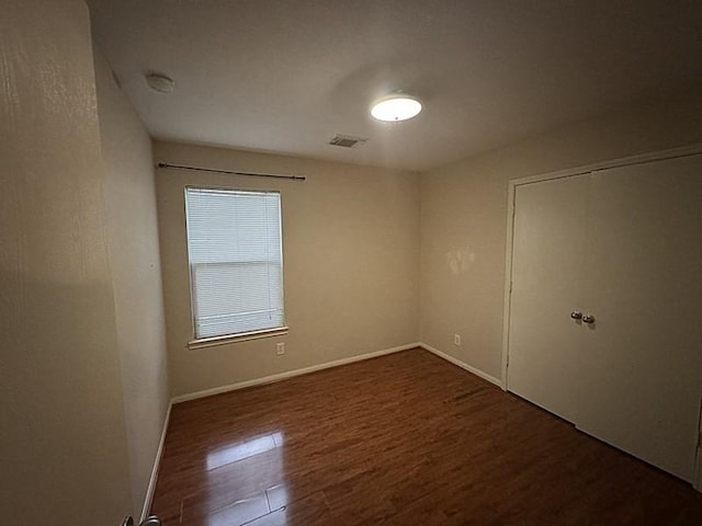 spare room featuring dark wood-type flooring