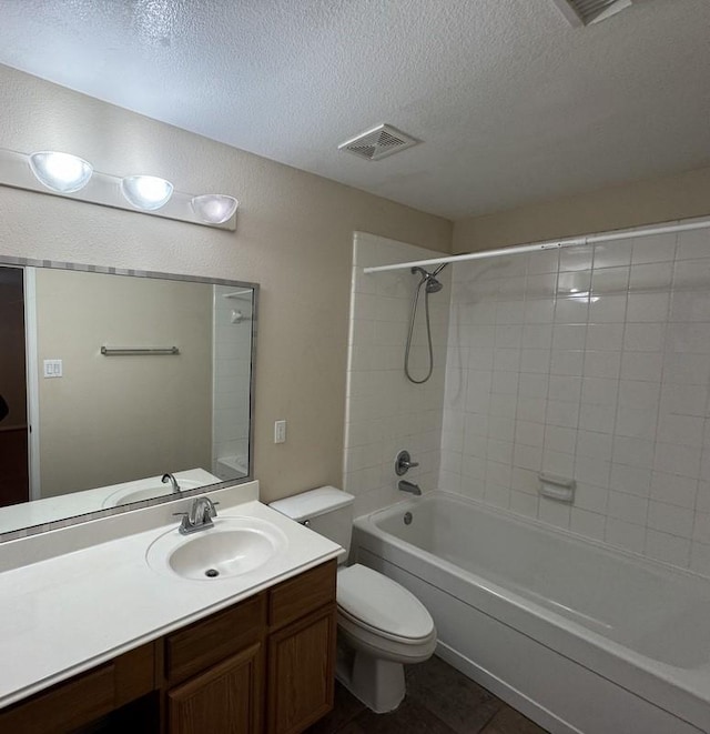 full bathroom featuring tiled shower / bath combo, toilet, a textured ceiling, and vanity