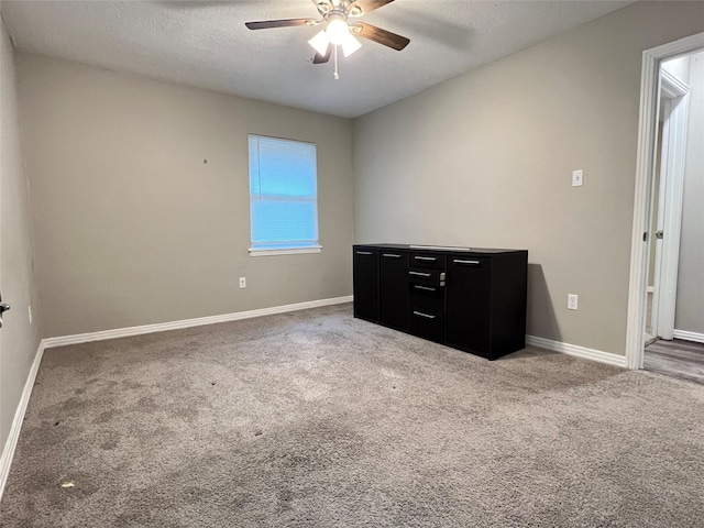 unfurnished bedroom featuring ceiling fan, carpet floors, and a textured ceiling