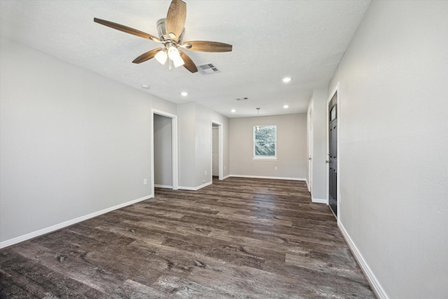 empty room with ceiling fan, dark hardwood / wood-style floors, and a textured ceiling