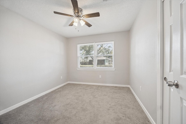 spare room featuring ceiling fan, carpet, and a textured ceiling