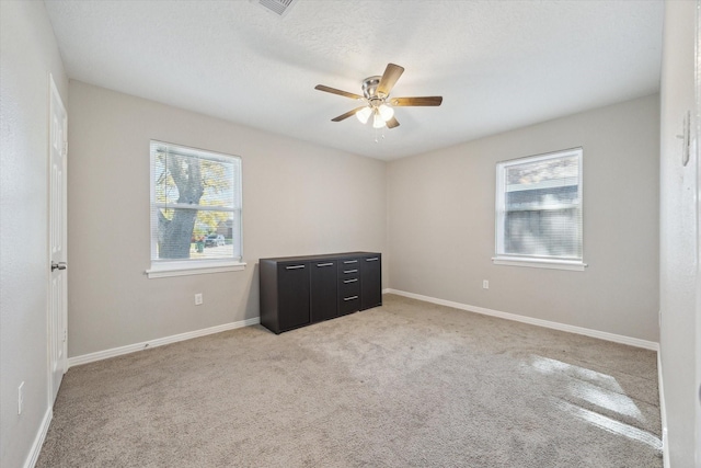 spare room featuring light carpet and ceiling fan