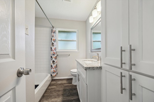 full bathroom featuring toilet, shower / bath combo with shower curtain, wood-type flooring, a textured ceiling, and vanity