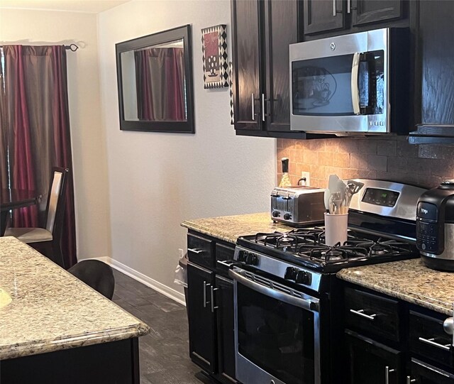 kitchen featuring light stone countertops, stainless steel appliances, and tasteful backsplash