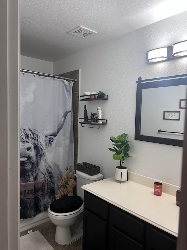 bathroom with a textured ceiling, toilet, vanity, and walk in shower