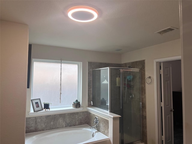 bathroom featuring shower with separate bathtub