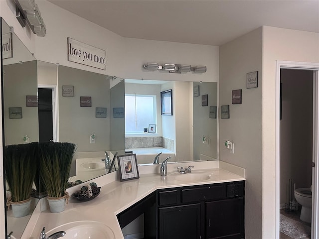 bathroom featuring a washtub, toilet, and vanity