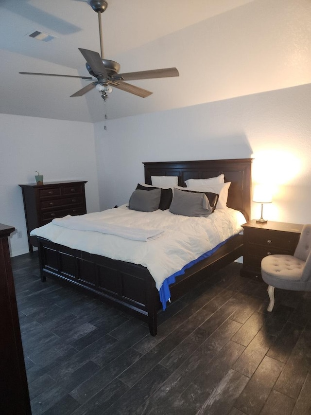 bedroom with ceiling fan, vaulted ceiling, and dark hardwood / wood-style flooring