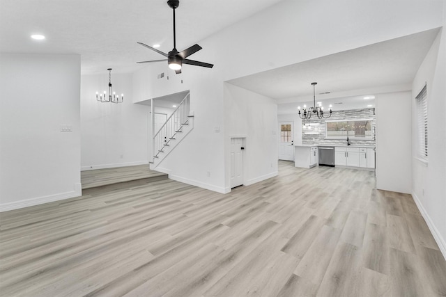 unfurnished living room with ceiling fan with notable chandelier and light wood-type flooring