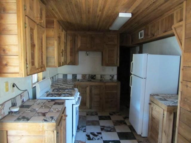 kitchen with tile counters, white appliances, and wood ceiling