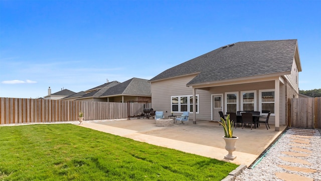 rear view of house with a patio, a fire pit, and a lawn