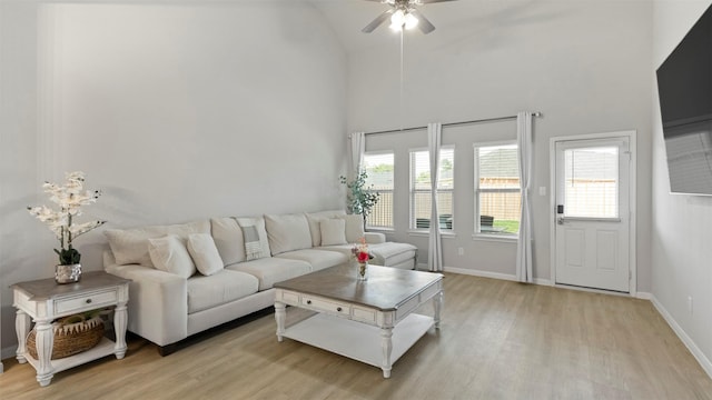 living room with ceiling fan, light wood-type flooring, and lofted ceiling