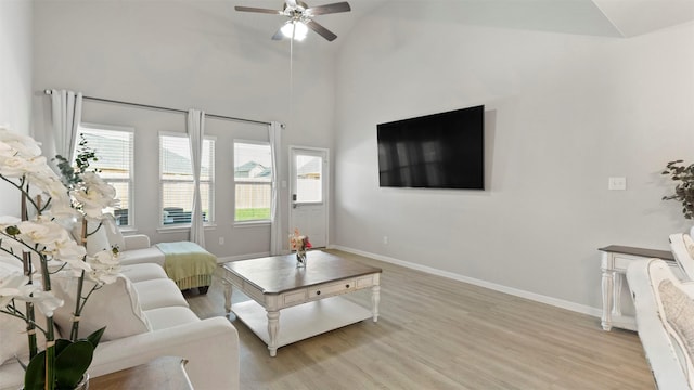 living room featuring ceiling fan, vaulted ceiling, and light hardwood / wood-style flooring