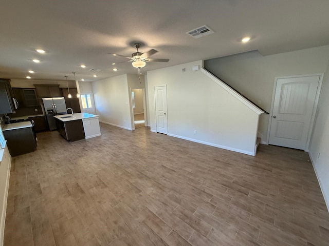 living room featuring ceiling fan, sink, and dark wood-type flooring