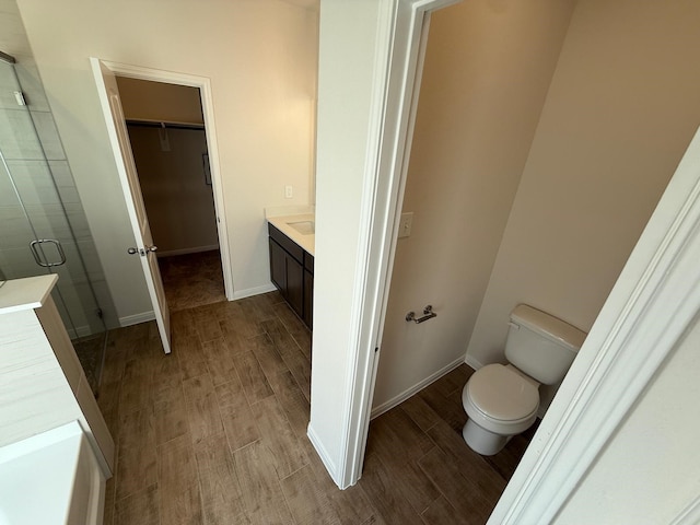 bathroom featuring vanity, toilet, and walk in shower