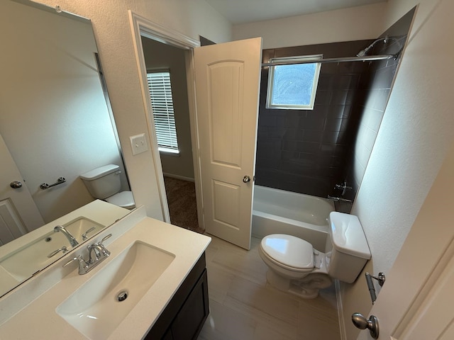 full bathroom with tile patterned flooring, vanity, tiled shower / bath combo, and toilet