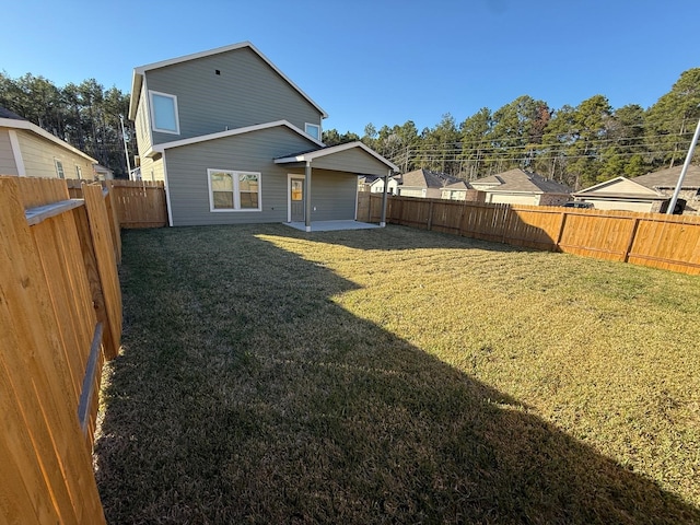 back of house with a lawn and a patio area