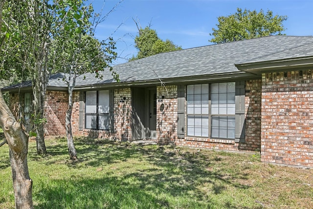 single story home featuring a front lawn