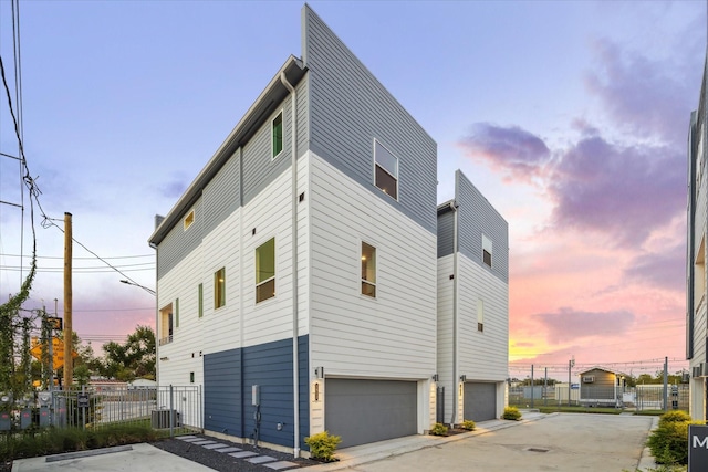 property exterior at dusk featuring a garage and central air condition unit