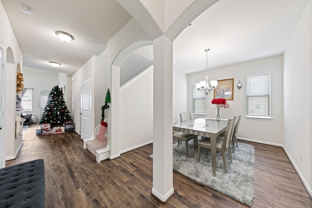 dining space featuring dark hardwood / wood-style flooring and a chandelier