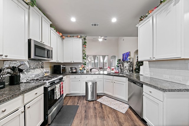 kitchen with ceiling fan, white cabinetry, sink, dark stone countertops, and stainless steel appliances