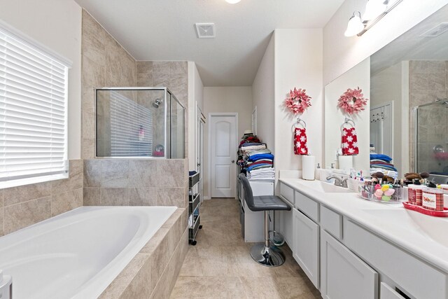 bathroom with tile patterned flooring, vanity, and shower with separate bathtub