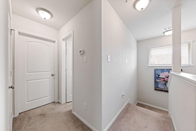 hallway featuring light colored carpet