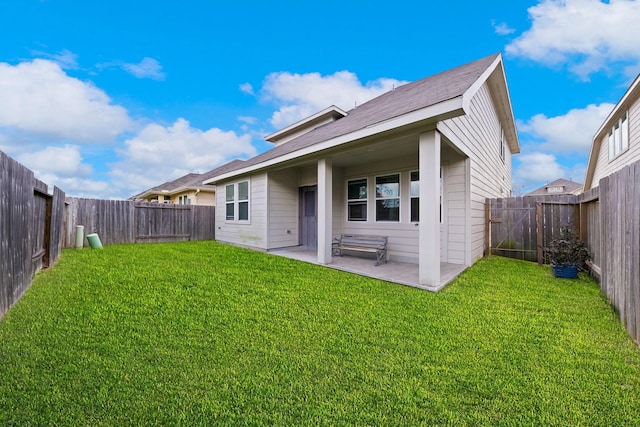 rear view of house with a lawn and a patio