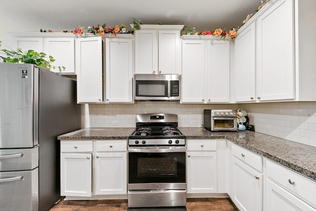 kitchen with white cabinetry, backsplash, stainless steel appliances, and stone countertops