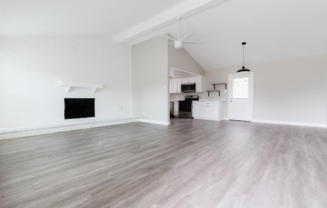 unfurnished living room with a brick fireplace, ceiling fan, light hardwood / wood-style floors, and lofted ceiling with beams