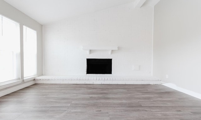 unfurnished living room with lofted ceiling, a healthy amount of sunlight, and a fireplace