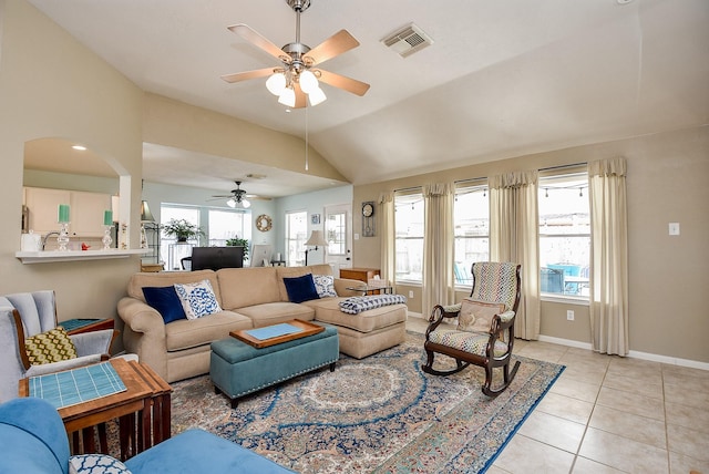 tiled living room with ceiling fan, a wealth of natural light, and vaulted ceiling