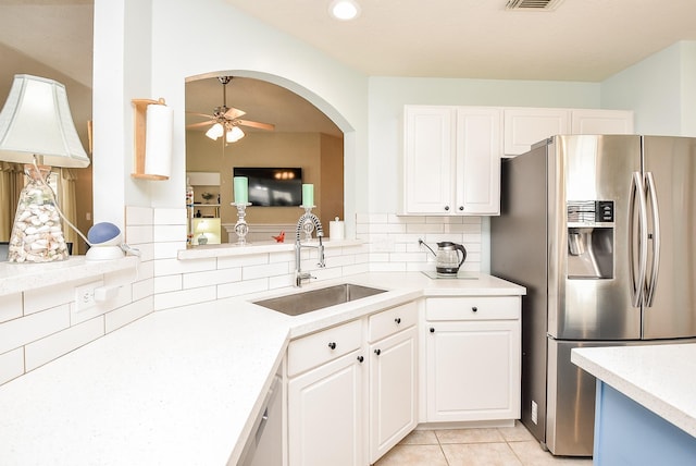 kitchen featuring sink, white cabinets, stainless steel fridge with ice dispenser, and light tile patterned floors