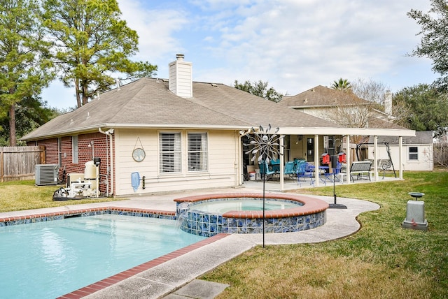 rear view of house with a patio area, a pool with hot tub, a lawn, and central air condition unit