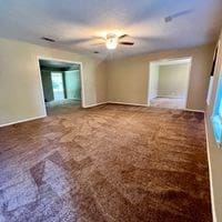 carpeted spare room featuring ceiling fan