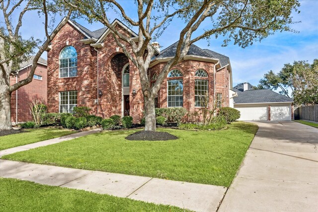 view of property with a garage and a front lawn