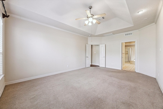 carpeted empty room featuring crown molding, ceiling fan, and a tray ceiling