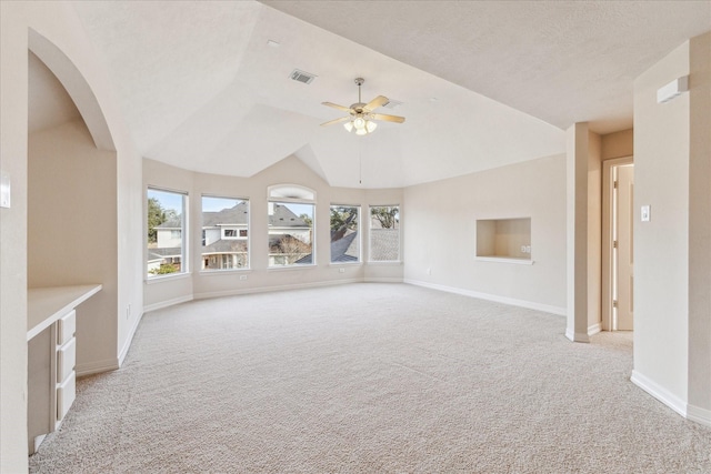 unfurnished living room with lofted ceiling, light carpet, plenty of natural light, and ceiling fan