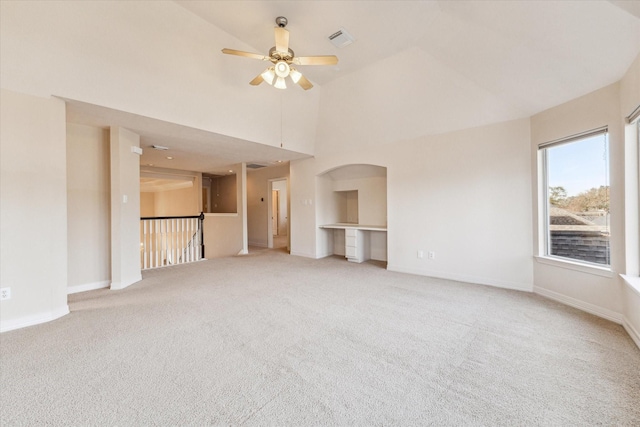 unfurnished living room with vaulted ceiling, carpet flooring, and ceiling fan