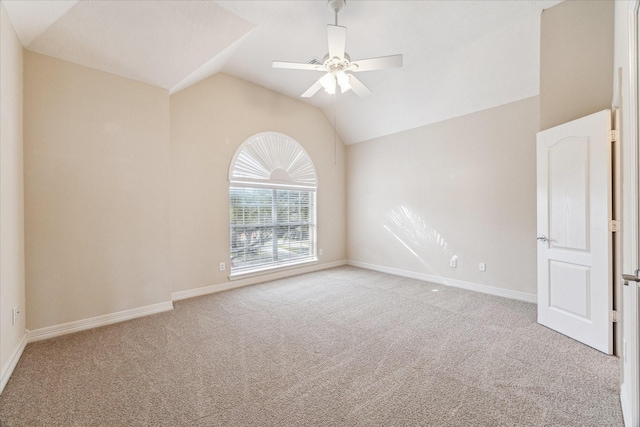 empty room with lofted ceiling, light colored carpet, and ceiling fan