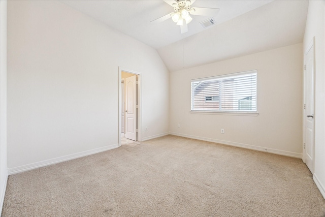 empty room featuring lofted ceiling, light colored carpet, and ceiling fan