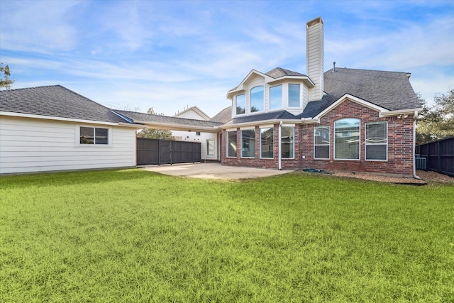 back of house with a patio and a lawn