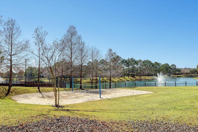 view of community featuring a water view, a yard, and volleyball court