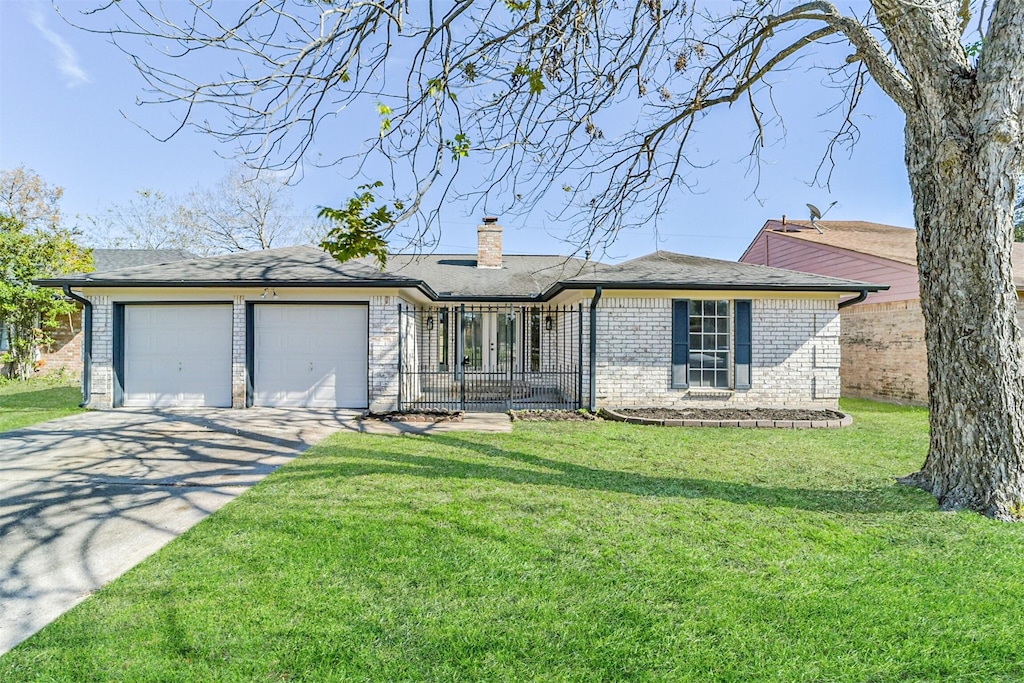 ranch-style home with a garage and a front lawn