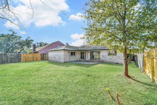 rear view of property featuring a patio area and a lawn