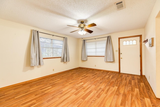 spare room featuring ceiling fan, a textured ceiling, and light hardwood / wood-style flooring