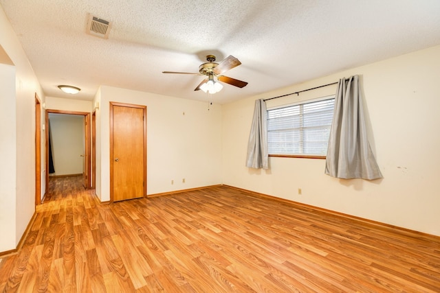 unfurnished room featuring ceiling fan, a textured ceiling, and light wood-type flooring